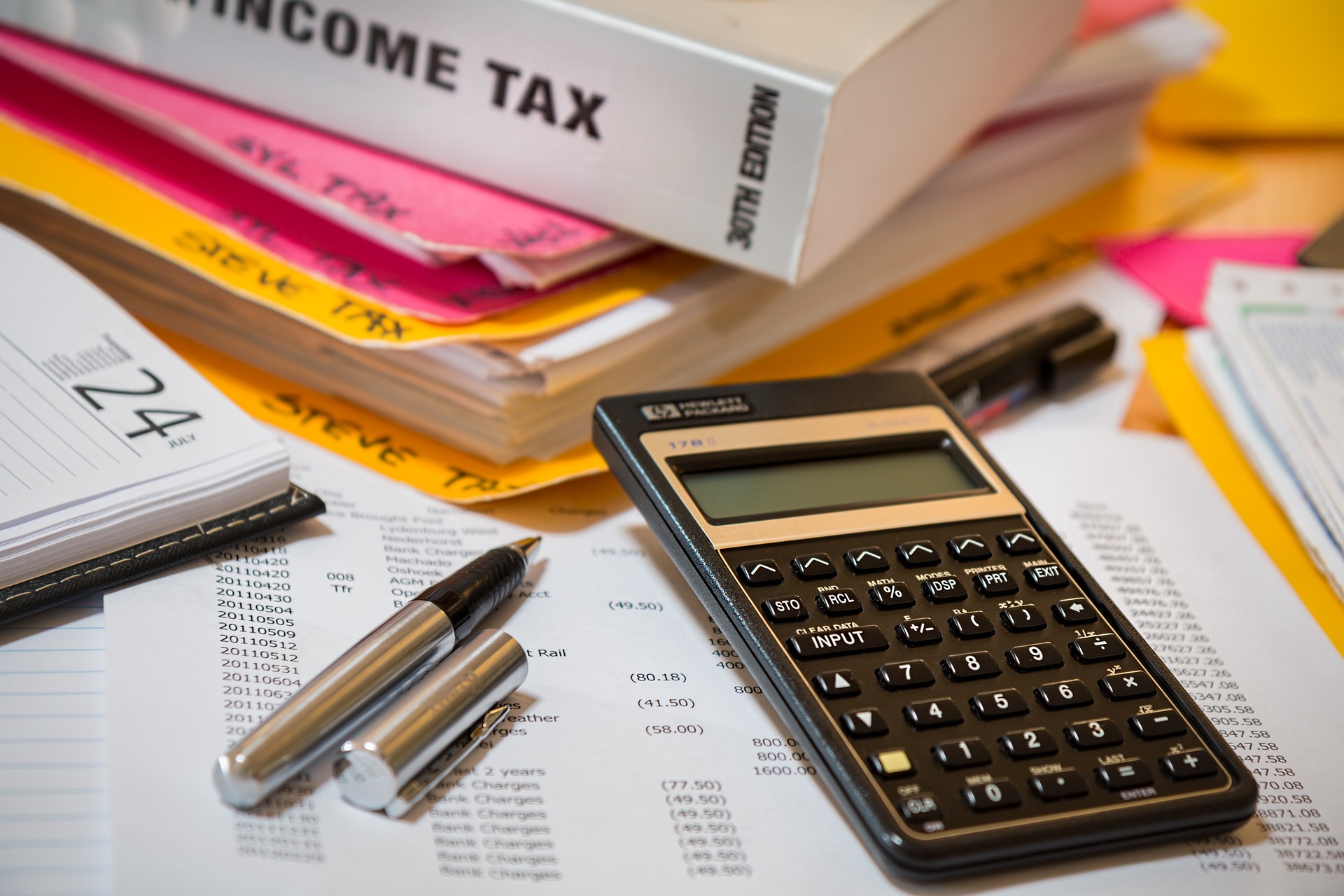 Classeur, calculatrice et autres documents pour remplir la déclaration d'impôts.